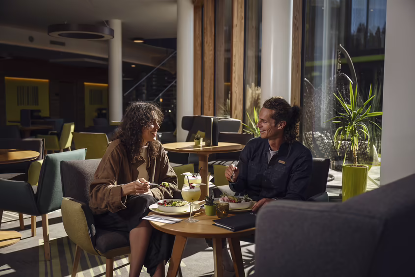 DAS SIEBEN - sieben Sinne | schmecken ©alexgretter Zwei Personen sitzen im Restaurantbereich von DAS SIEBEN und essen gemeinsam