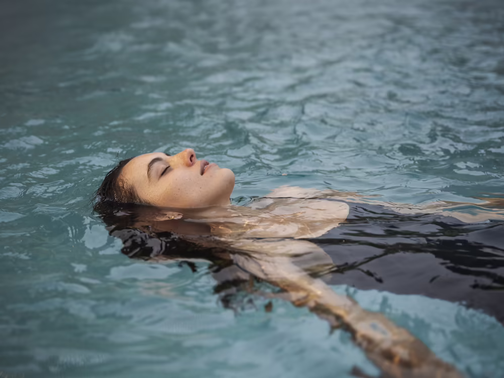 DAS SIEBEN - Für Sinne, die erwachen, für Energie, die bleibt ©alexgretter Frau entspannt im Wasser im Wellnessbereich des Hotels DAS SIEBEN