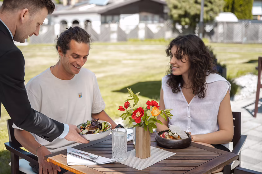 DAS SIEBEN - sieben Sinne | schmecken ©alexgretter Zwei Personen sitzen auf der Terrasse im DAS SIEBEN Hotel und essen gemeinsam.